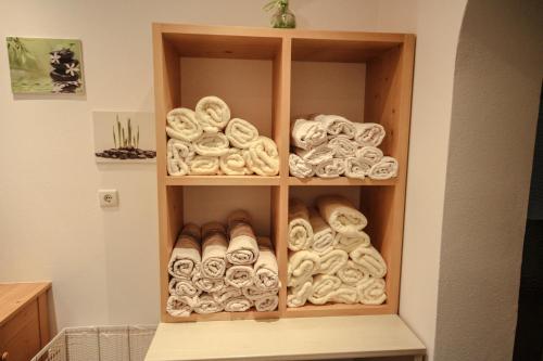 een boekenplank gevuld met veel handdoeken bij Hotel Cornelia in Solda