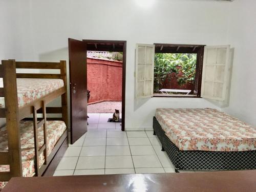 1 dormitorio con 2 literas y ventana en Chalés Damata, en Ubatuba