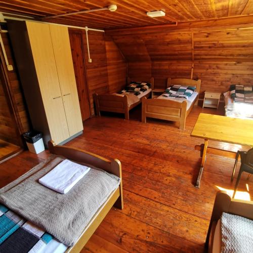 a room with two beds in a wooden cabin at SzSM Hadle Szklarskie in Hadle Szklarskie