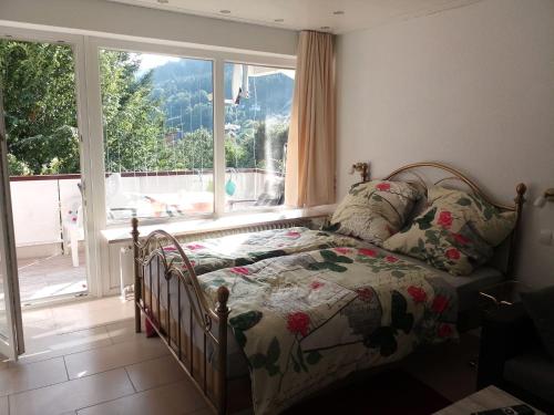 a bedroom with a bed in front of a window at Ferienwohnung Tannenwald in Bad Wildbad