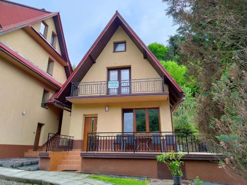 a house with a balcony and a porch at Agroturystyka u Zbyszka in Tylmanowa