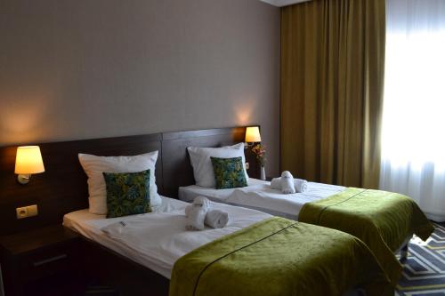 a hotel room with two beds with stuffed animals on them at Hotel & Browar Słociak in Opole
