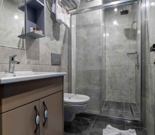 a bathroom with a shower and a toilet and a sink at THE NOVA HOTEL in Yalova