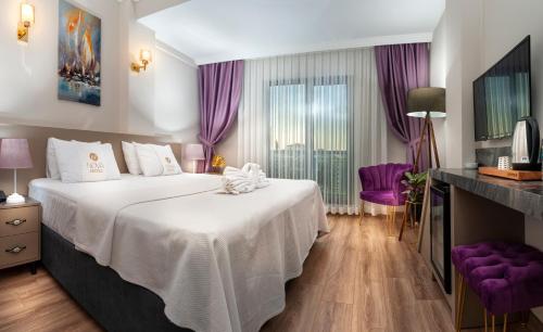 THE NOVA HOTEL في يالوفا: غرفة نوم بسرير كبير مع ستائر ارجوانية