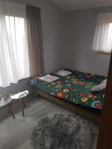 a small bedroom with a bed and a rug at Domki nad Nieliszem - dom brzozowy in Nielisz