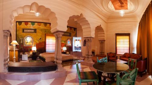 a large room with a bed and a table and chairs at Neemrana's - Tijara Fort Palace in Alwar