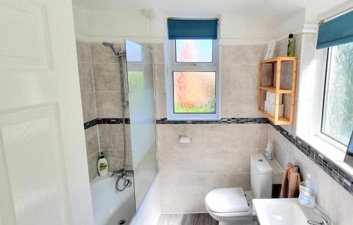 een badkamer met een douche, een toilet en een wastafel bij Victoria Road, comfortable 3 bedroom houses with fast Wi-Fi in Sittingbourne