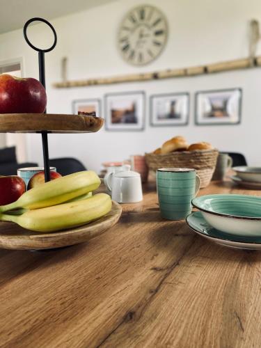 einen Holztisch mit Früchten und Platten darauf in der Unterkunft [E]ifeel like Home in Hauroth
