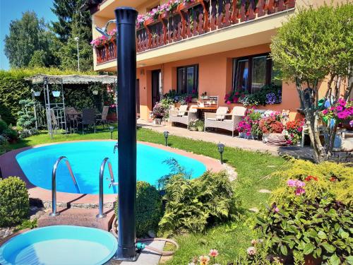 a swimming pool in the yard of a house at Apartmány u Jiroušů in Rokytnice nad Jizerou