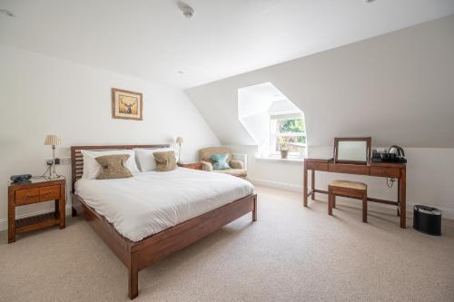 a bedroom with a bed and a desk and a window at Ardeonaig Hotel & Restaurant in Ardeonaig