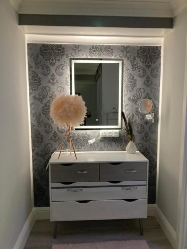 een witte dressoir met een spiegel en een tv bij Vakantie Villa Hengelhoef in Zonhovenheide