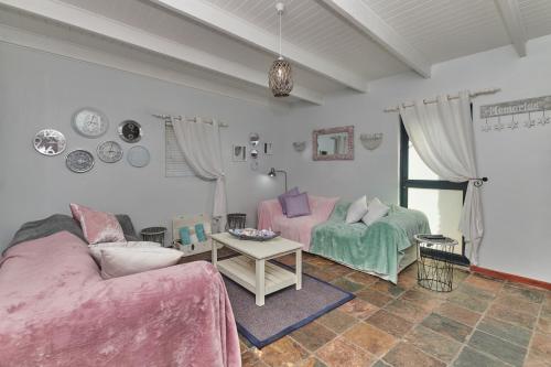 una sala de estar con dos camas y un sofá en Fraai Uitzicht Struisbaai, en Struisbaai