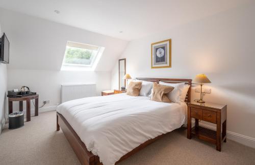 a bedroom with a large white bed and a window at Ardeonaig Hotel & Restaurant in Ardeonaig