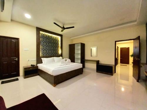 a bedroom with a large white bed in a room at Royal Destiny Resort in Malaiyāndipattanam