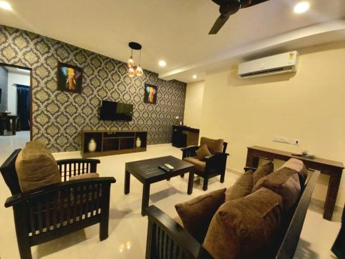 a living room with a couch and chairs and a fireplace at Royal Destiny Resort in Malaiyāndipattanam