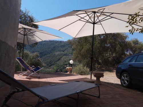 a patio with a chair and an umbrella at L'Antica Quercia B&B in CastellʼUmberto