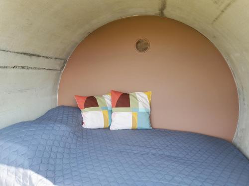 ein Bett mit zwei bunten Kissen in einem Zimmer in der Unterkunft RIP by Říp in Krabčice