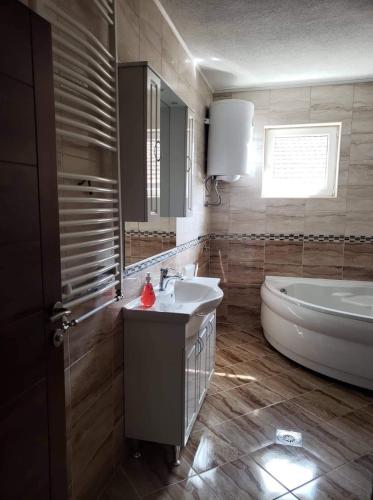 a bathroom with a tub and a sink and a bath tub at Apartmani Ambiente in Plav