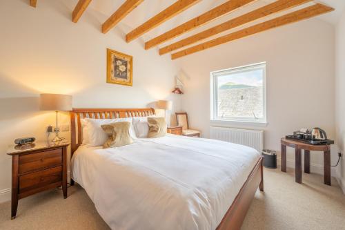 a bedroom with a large white bed and a window at Ardeonaig Hotel & Restaurant in Ardeonaig