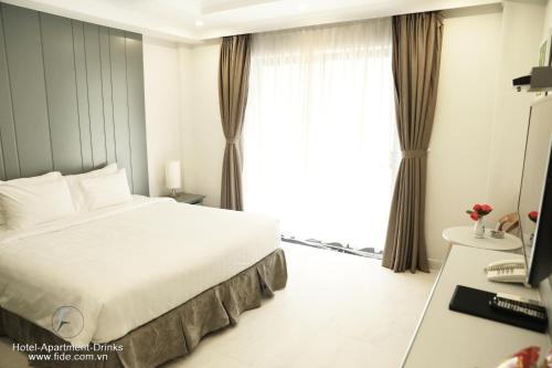 a hotel room with a bed and a window at Fide Hotel in Ho Chi Minh City