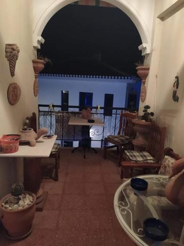 Ενοικιαζόμενα δωμάτια Ματούλα Κοχειλα في سبيتسيس: غرفة مع طاولة وكراسي وشخص يجلس على طاولة
