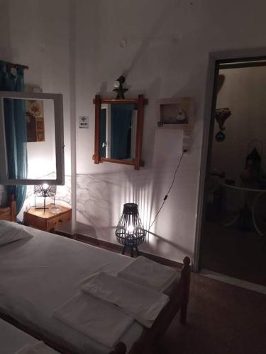 una camera con letto, specchio e lampada di Ενοικιαζόμενα δωμάτια Ματούλα Κοχειλα a Spetses