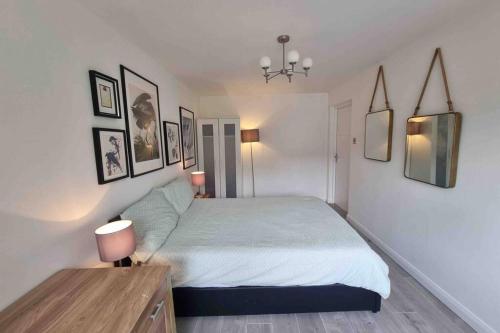 a bedroom with a bed and some pictures on the wall at The Bungalow in Chesterton