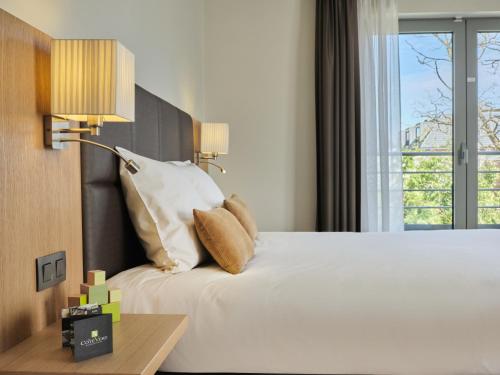 a bedroom with a large white bed and a window at Le Côté Vert in Waterloo