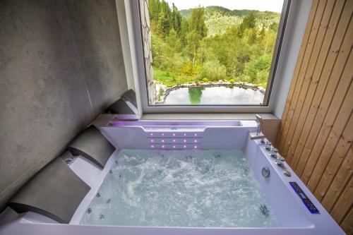 a bath tub in a room with a window at Bukówka Luksusowa Bacówka in Ochotnica Dolna