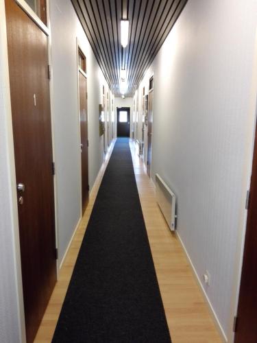 długi korytarz z długim czarnym dywanem w budynku w obiekcie Motelli Karjala w mieście Uimaharju