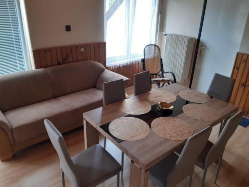 a living room with a wooden table and a couch at Toldi Apartman in Keszthely