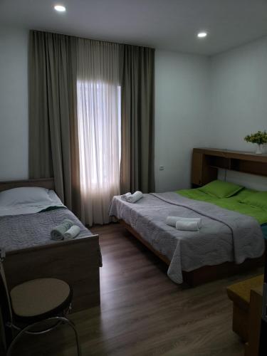 una camera d'albergo con due letti e una finestra di Guest House Nanu a Mestia