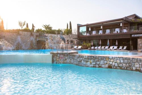 a swimming pool with a water fountain in a resort at Le Ali Del Frassino in Peschiera del Garda