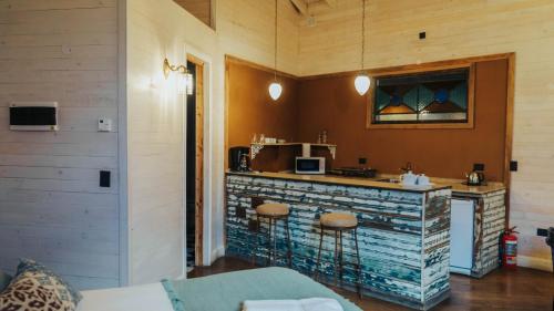 a kitchen with a counter with stools in a room at Departamentos de El Mercado in Villa La Angostura