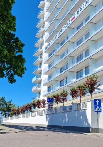 a tall white building with plants on it at Apartament Prestige & Sea Balticus A4 in Międzyzdroje