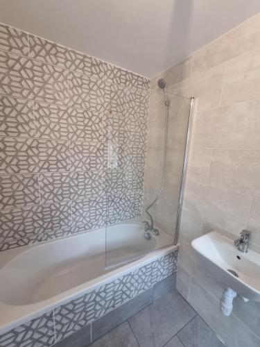 a bathroom with a shower and a tub and a sink at The Bungalow in Chesterton