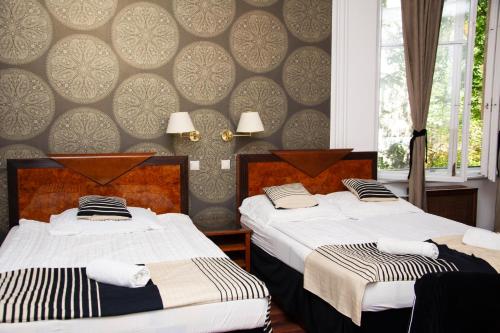 1 dormitorio con 2 camas y pared en Evergreen Budapest Guest House, en Budapest