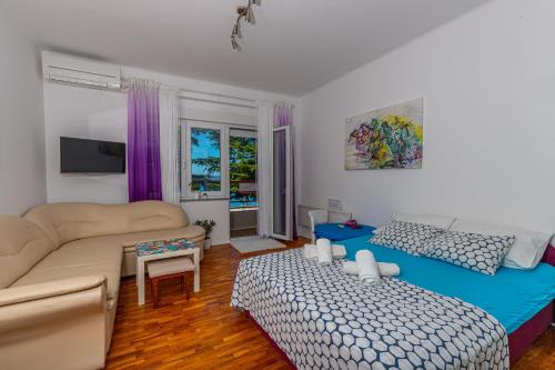 een woonkamer met een bank en een bed bij Crikvenica Right On The Beach in Crikvenica