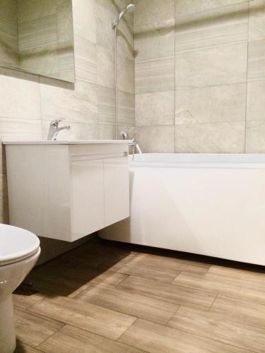a bathroom with a sink and a tub and a toilet at Yin Shan Hotel in Zhongzheng