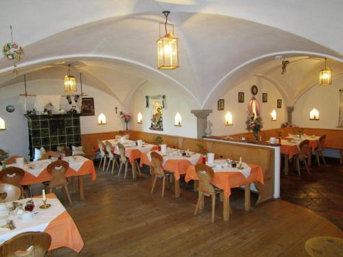 a restaurant with tables and chairs in a room at Schellenberger Hof in Soyen