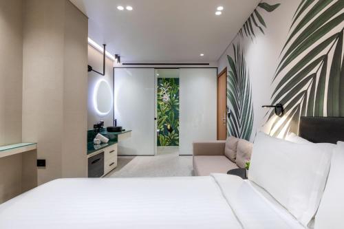 a bedroom with a white bed and a couch at Amazon Hotel in Athens
