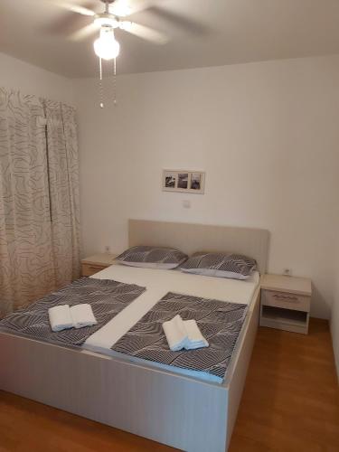 a bedroom with a bed with two towels on it at Apartments Katica in Rab