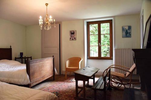 a bedroom with a bed and a table and a chair at Moulin dans un parc d’élevage à Daims in Jancigny