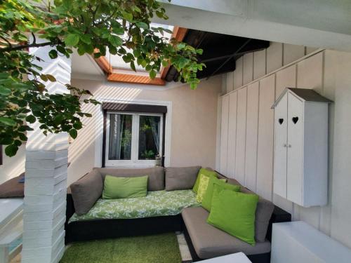 eine kleine Terrasse mit einem Sofa und einem Fenster in der Unterkunft Ferienwohnung Eder in Pöcking