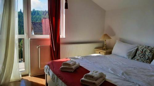 a bedroom with a bed with two towels on it at Pensiunea Karola in Păltiniş