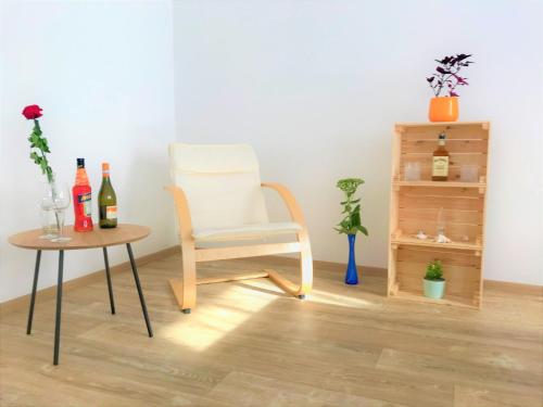 Habitación con silla y mesa con botellas de vino en Sportovni apartman, en Náchod