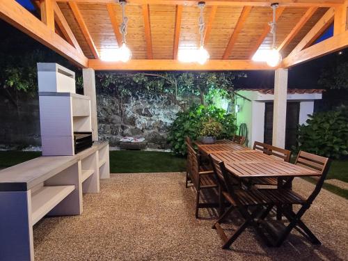 um pátio exterior com uma mesa de madeira e cadeiras em Casa de Ladrido em Felgueiras