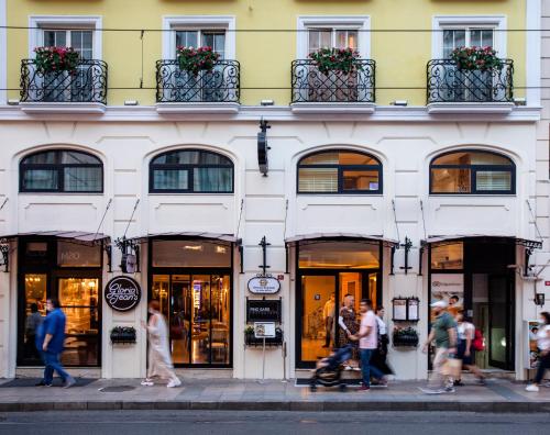 people are walking down the street in front of a store at Orient Express & Spa by Orka Hotels in Istanbul