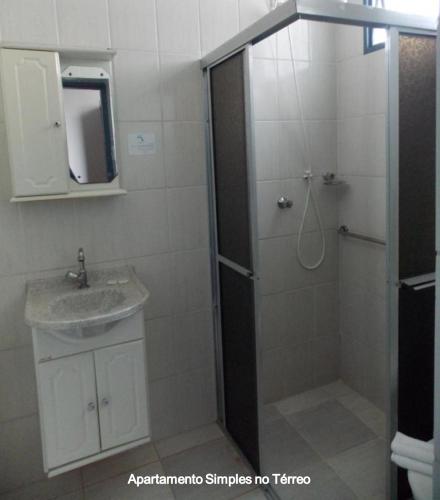 a bathroom with a shower and a sink and a mirror at MOVA Hotel D'oeste - Localizado em frente a Praça Principal da Cidade, na área Central - Pé na Praça in Poços de Caldas