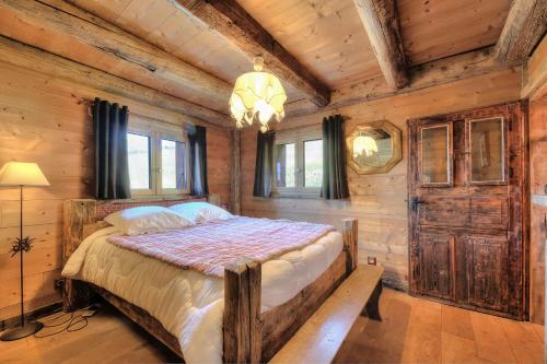 a bedroom with a bed in a log cabin at IMMOBILIER DE MONTAGNE - LA COLLECTION - L'alpage in Saint-Gervais-les-Bains